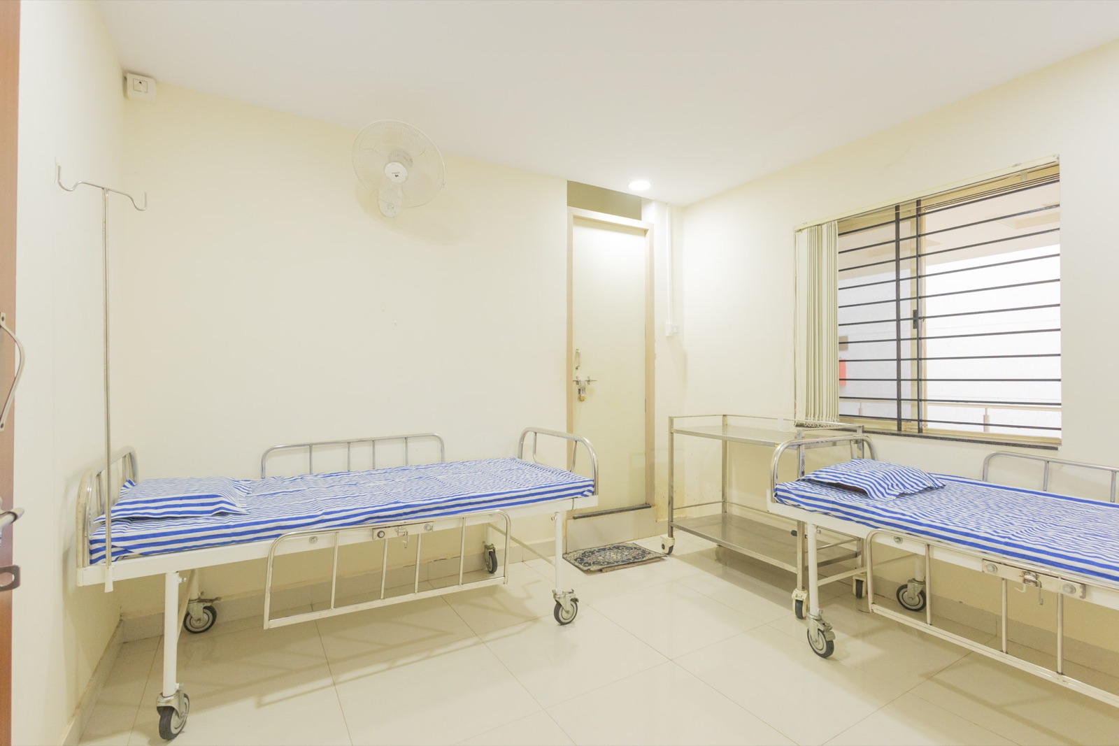 Patient recovery room with two beds at Srishti SAFE clinic, Hubli