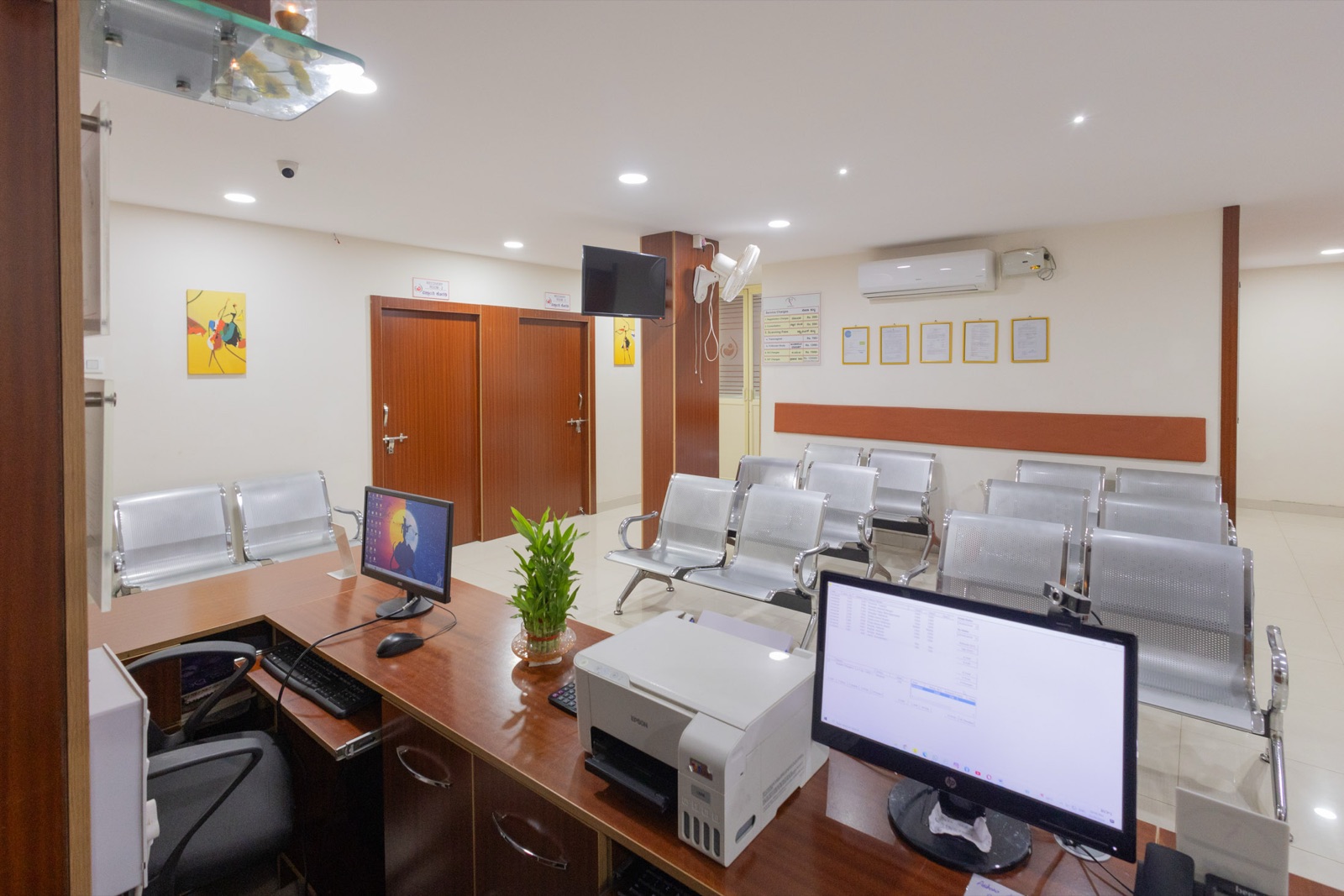 Wide view of Srishti SAFE waiting area with seating, display screens and reception desk